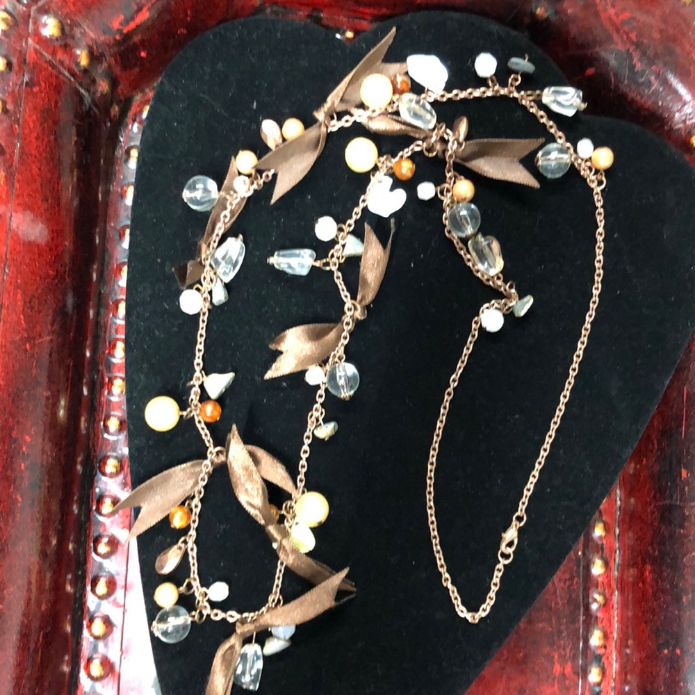 copper colored chain brown ribbon and a multitude of different stones 18 inches